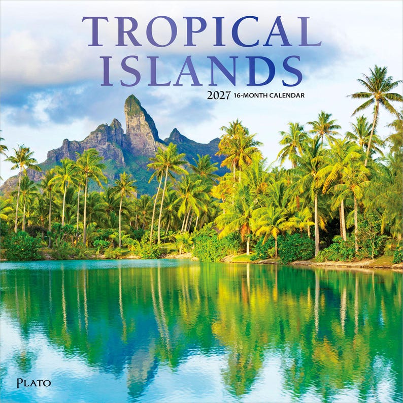 May include: A 2027 16-month calendar titled TROPICAL ISLANDS featuring a landscape photograph of a calm turquoise lagoon reflecting a lush shoreline filled with numerous tall palm trees and a large, jagged mountain peak under a cloudy sky.