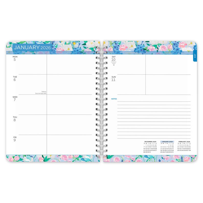 May include: Open spiral-bound planner for January 2026, featuring a floral border with blue, pink, and white flowers. The left page displays the week's days, while the right page has space for notes. The month and year are printed at the top.