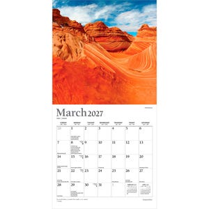 Op de afbeelding: Een wandkalenderpagina voor maart 2027 met een foto van oranje en rode zandsteenformaties onder een blauwe lucht. Het raster toont de data van zondag tot zaterdag met kleine tekst voor feestdagen en maanfasen gedurende de maand.