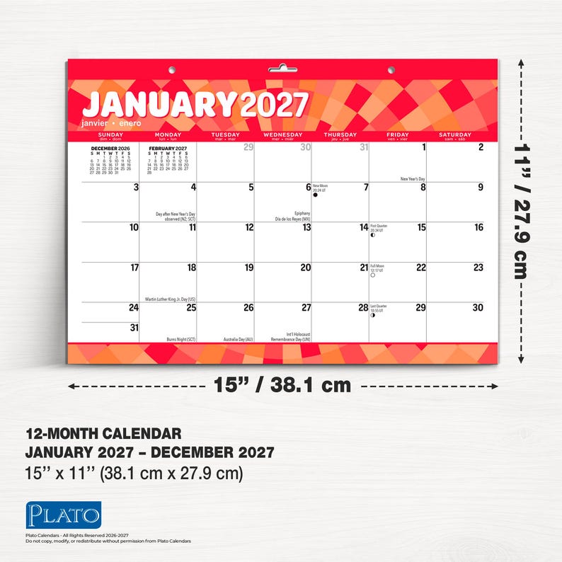 Puede incluir: Un calendario de pared para enero de 2027 con un encabezado de rayos de sol geom&eacute;tricos en rojo y naranja. La cuadr&iacute;cula muestra fechas, d&iacute;as festivos y fases lunares. Mide 38,1 cm de ancho por 27,9 cm de alto con un orificio para colgar.