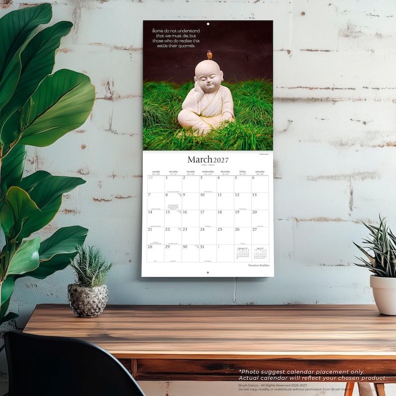 May include: A wall calendar for March 2027 featuring a photograph of a small white Buddha statue sitting in green grass with a tiny bird on its head. The text reads: Some do not understand that we must die, but those who do realize this settle their quarrels.