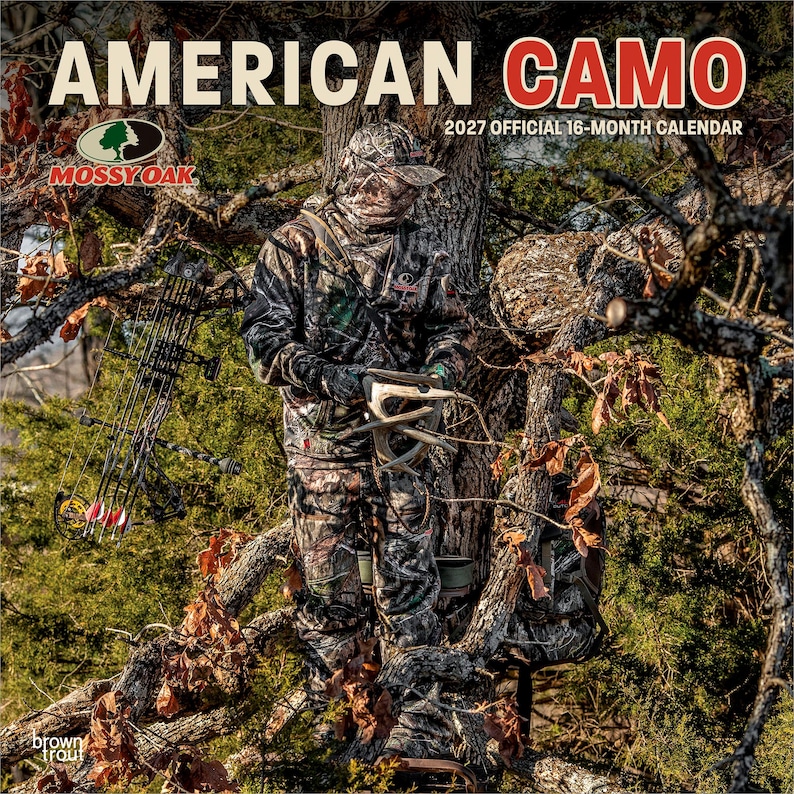以下が含まれることがあります： AMERICAN CAMOと記された2027年公式16ヶ月カレンダー。Mossy Oakのロゴ入り。表紙には、迷彩服を着て木の上に立ち、鹿の角を手にした人物と、枝に掛けられたコンパウンドボウが写っている。