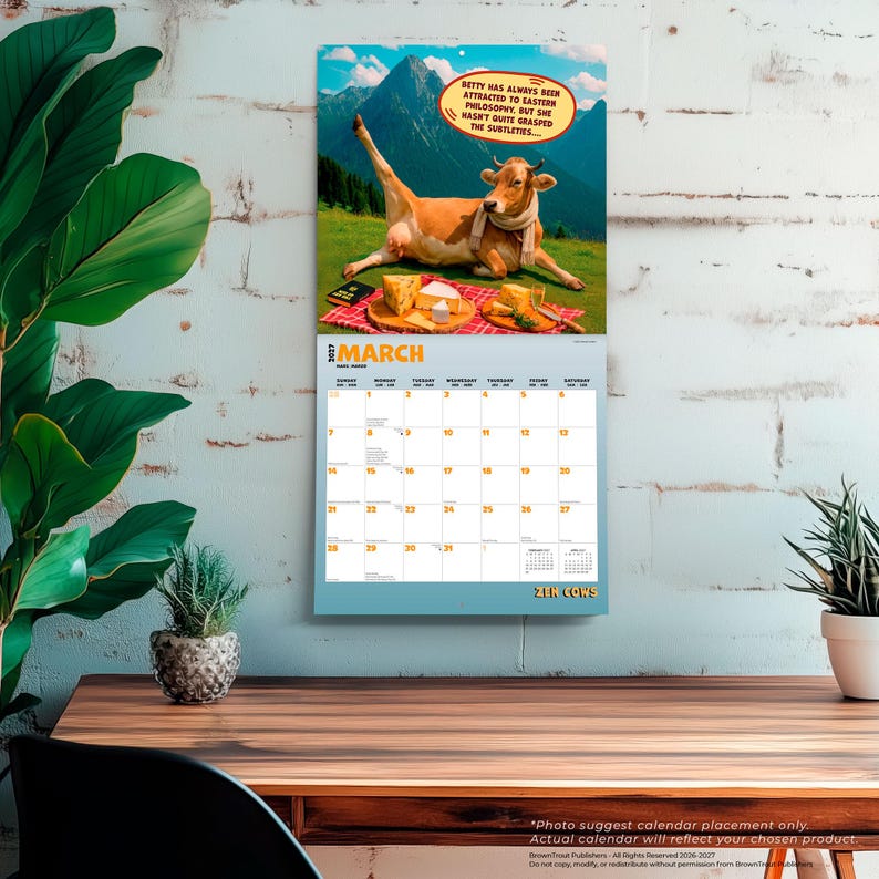 Pode incluir: Um calend&aacute;rio de parede para mar&ccedil;o de 2027 intitulado Zen Cows. A imagem superior mostra uma vaca castanha com um cachecol num prado de montanha com queijo sobre um pano aos quadrados vermelhos. Um bal&atilde;o de fala diz: Betty has always been attracted to eastern philosophy, but she hasn't quite grasped the subtleties.