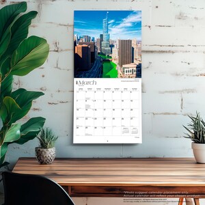 May include: A wall calendar for March 2024 featuring a high-angle photograph of the Chicago skyline with the Chicago River dyed bright green. The calendar grid displays dates from the first to the thirty-first with a white background and black text.