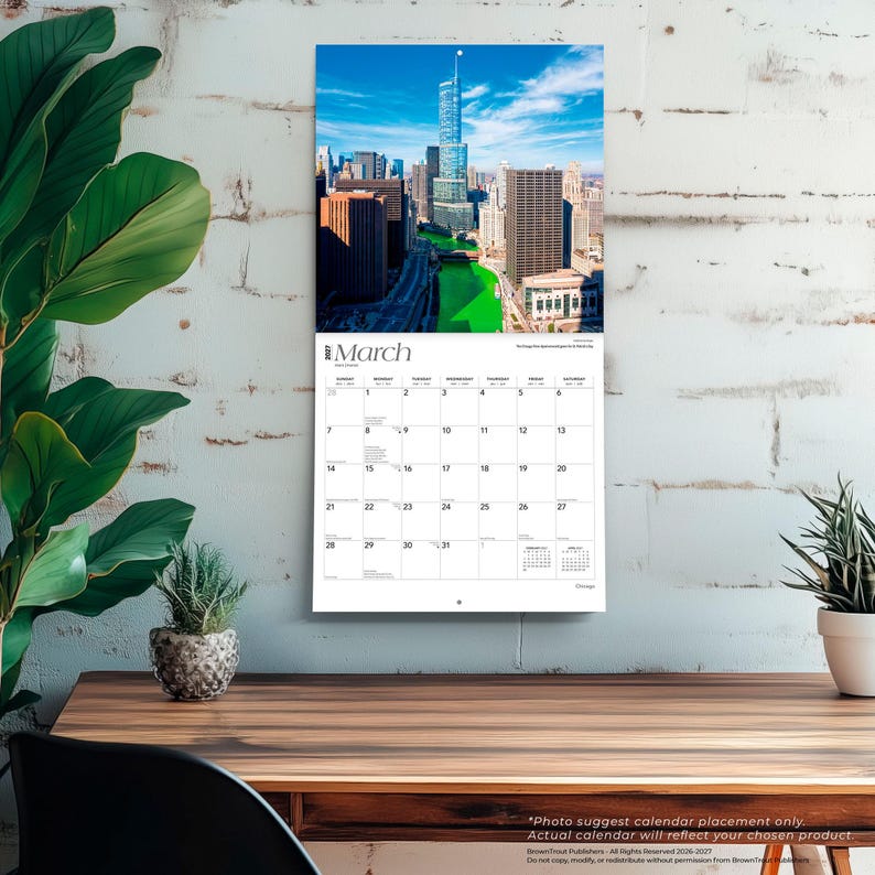 May include: A wall calendar for March 2024 featuring a high-angle photograph of the Chicago skyline with the Chicago River dyed bright green. The calendar grid displays dates from the first to the thirty-first with a white background and black text.