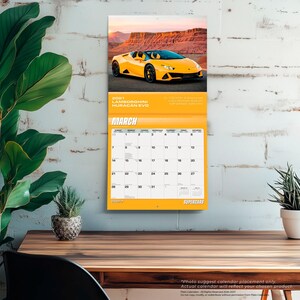 May include: A 2021 wall calendar featuring a yellow Lamborghini Huracan Evo sports car on the top page. The calendar page displays the month of March with a grid of dates, the text 2021 LAMBORGHINI HURACAN EVO, and the word SUPERCARS at the bottom.