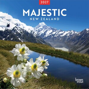 May include: A 2027 wall calendar titled Majestic New Zealand featuring a photograph of white flowers with yellow centers in the foreground, a small stream, and snow-capped mountains under a clear blue sky. The brand name BrownTrout is visible.