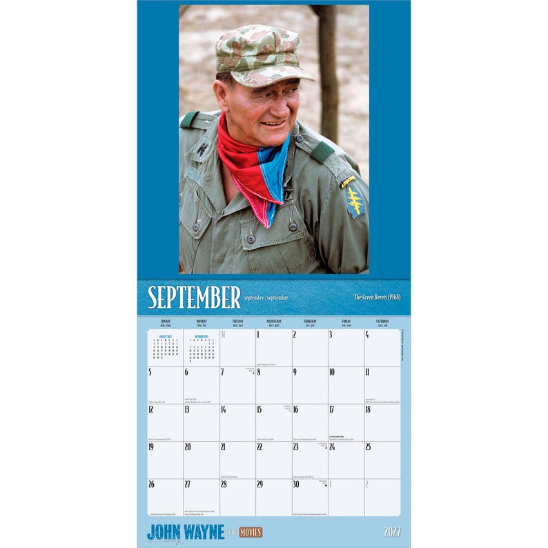 May include: A calendar featuring a portrait of John Wayne in a military uniform, with a red, blue, and pink scarf. The calendar displays the month of September, with the year 2022 at the bottom. The words "John Wayne Movies" are also visible.