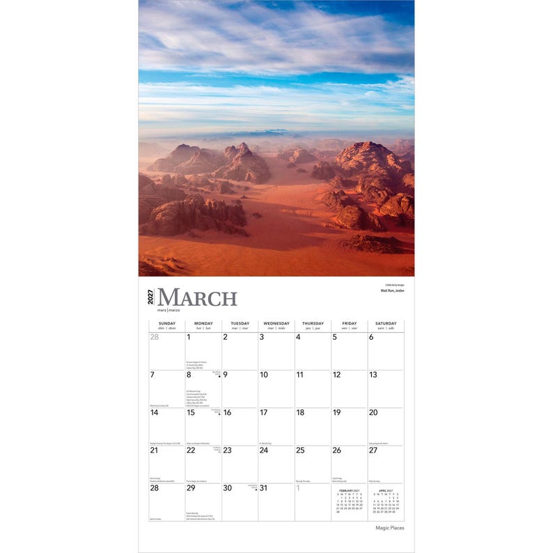 May include: A 2027 wall calendar for the month of March featuring a landscape photograph of the Wadi Rum desert in Jordan. The image displays red sand dunes and rocky mountains under a blue sky. The calendar grid shows dates from 1 to 31.