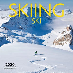 Peut inclure: Calendrier 2026 avec un paysage de montagne enneig&eacute; et un skieur tra&ccedil;ant un chemin dans la neige. Le mot "SKIING" est en grandes lettres jaunes en haut, avec "SKI" en dessous. Calendrier de 16 mois.