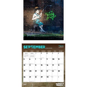 May include: A calendar featuring Banksy's graffiti art. The image shows a boy fishing with a green graffiti fish on a brick wall. The calendar displays the month of September, with dates from 2021.