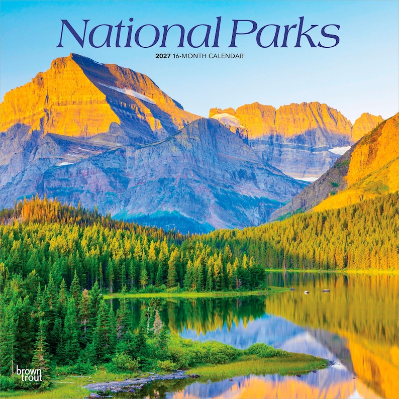 Puede incluir: Un calendario de 16 meses de 2027 con un paisaje de monta&ntilde;as, un lago y un bosque. Las palabras "National Parks" est&aacute;n en la parte superior en azul marino. La imagen muestra una escena natural con un cielo azul y un reflejo en el lago.