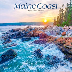 May include: A 2027 16-month calendar titled Maine Coast featuring a scenic photograph of a rocky shoreline with crashing turquoise waves, a dense evergreen forest, and a bright sunset over the horizon, with the brand name brown trout visible.