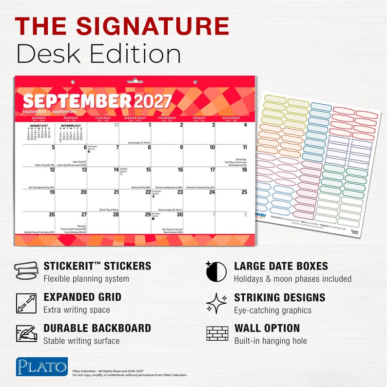 Puede incluir: Un calendario de pared de septiembre de 2027 titulado The Signature Desk Edition con un borde geom&eacute;trico rojo y naranja, que presenta una cuadr&iacute;cula mensual con d&iacute;as festivos y fases lunares, junto a una hoja de pegatinas rectangulares de colores.