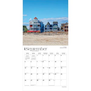 May include: A 2027 wall calendar for the month of September featuring a photograph of multi-storey beachfront houses in Cape May, New Jersey. The calendar grid displays the days of the month with black text on a white background under a blue sky.
