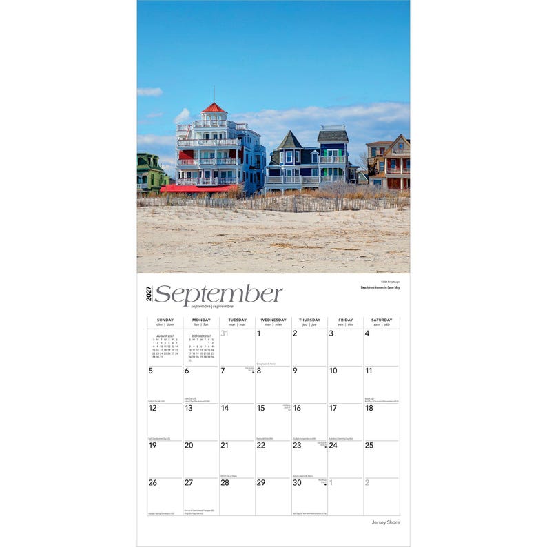 May include: A 2027 wall calendar for the month of September featuring a photograph of multi-storey beachfront houses in Cape May, New Jersey. The calendar grid displays the days of the month with black text on a white background under a blue sky.