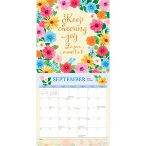 K&ouml;nnte beinhalten: Ein Wandkalender f&uuml;r September 2027 mit einem Blumenrand aus rosa, gelben, orangefarbenen und blauen Bl&uuml;ten. Der obere Teil zeigt den Text Keep choosing joy und La joie avant tout. Der untere Teil zeigt das Kalendergitter f&uuml;r September 2027.