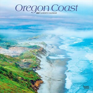 May include: A 2027 16-month calendar titled Oregon Coast, featuring a high-angle landscape photograph of a misty coastline with green grassy cliffs, sandy beaches, and blue ocean waves under a cloudy sky, with the BrownTrout logo in the corner.