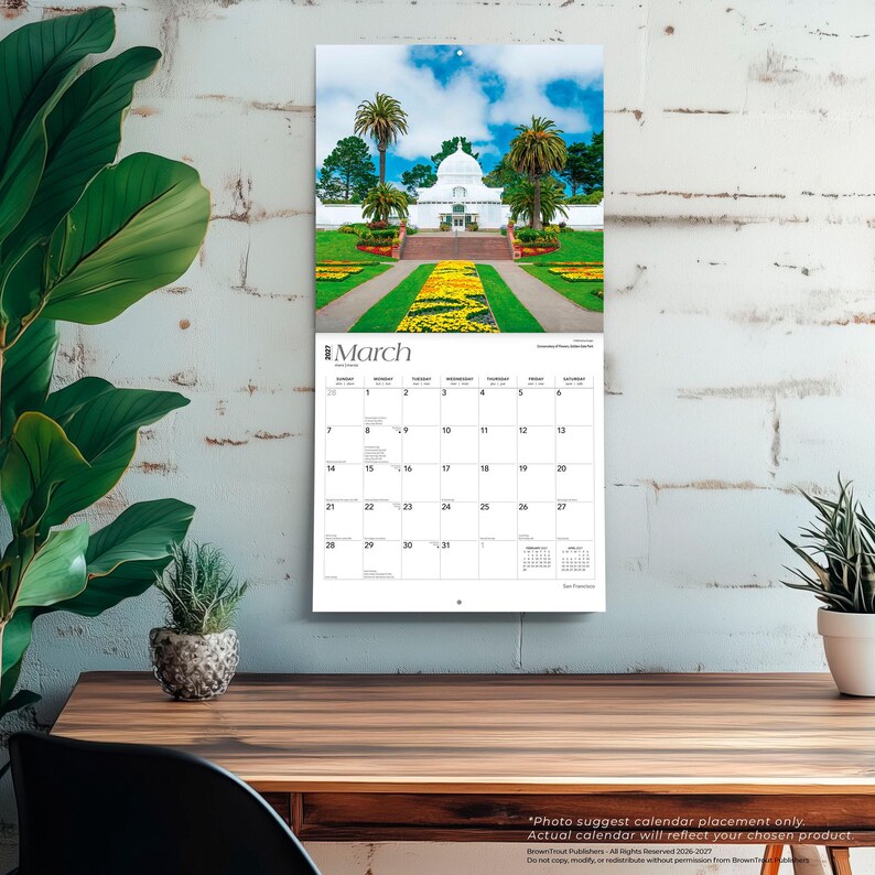 May include: A wall calendar for March 2024 featuring a photograph of a white domed conservatory building surrounded by palm trees, green lawns, and yellow flower beds. The calendar grid displays the days of the month with clear black text.