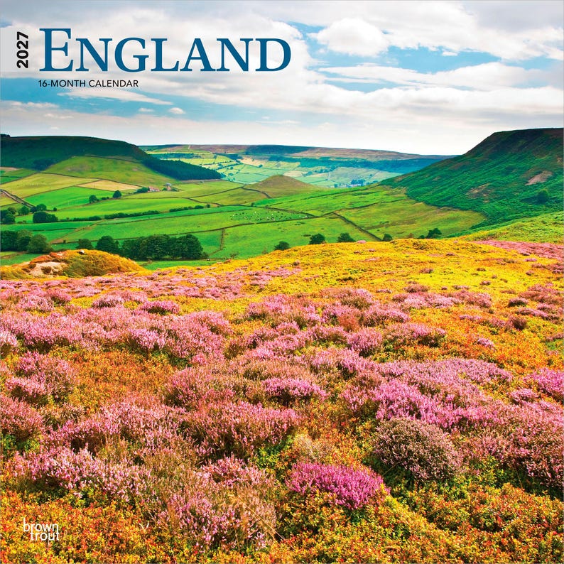 May include: A 2027 England 16-month calendar featuring a landscape photograph of rolling green hills and a vibrant foreground of pink and yellow heather under a blue sky with white clouds. The text 2027 ENGLAND 16-MONTH CALENDAR is printed at the top.