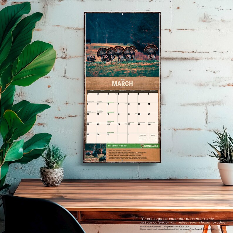 May include: A wall calendar featuring a wildlife scene with turkeys. The top portion displays a photograph of turkeys in a field, with the month of "March" printed in a brown banner. The calendar grid is below, with a "Gamekeeper" logo.