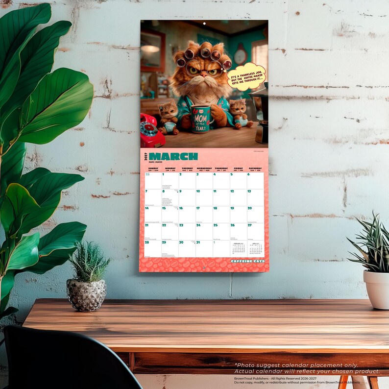 May include: A 2027 wall calendar for March featuring a grumpy orange cat with hair rollers holding a mug that says Mom of the Year. Two small kittens sit nearby. The text reads It's a thankless job, but the coffee makes me through it and Caffeine Cats.