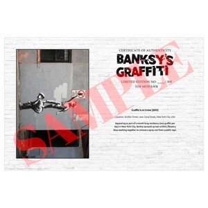 May include: A certificate of authenticity for Banksy's Graffiti, a limited edition print. The artwork depicts a street scene with figures and text. The text reads "BANKSY'S GRAFFITI" and "Graffiti Is A Crime (2013)". The print is numbered 115/300.