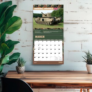 Puede incluir: Un calendario de pared de 2027 con un tanque Churchill Crocodile en la p&aacute;gina de marzo. La secci&oacute;n superior muestra el tanque en un campo de hierba con el texto Churchill Crocodile y una bandera brit&aacute;nica. La secci&oacute;n inferior muestra el calendario.