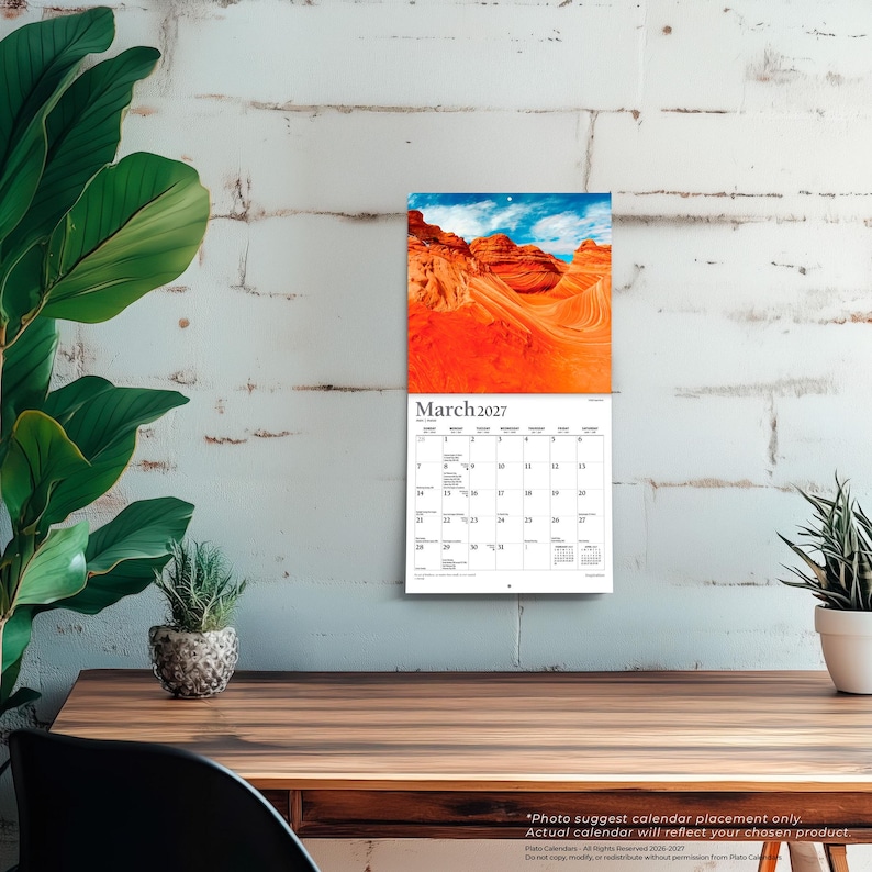 Op de afbeelding: Een wandkalender voor maart 2027 met een foto van oranje zandsteenformaties onder een blauwe lucht. Het kalenderraster toont de dagen van de maand met zwarte tekst op een witte achtergrond, inclusief de maand en het jaar bovenaan.