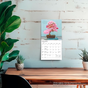 Peut inclure: Un calendrier mural pr&eacute;sentant une photographie d'un bonsa&iuml; aux fleurs roses dans un pot rectangulaire. La page du calendrier affiche le mois de mars, avec une grille de dates et le texte 'MARS' et 'March' imprim&eacute;s en haut de la section.