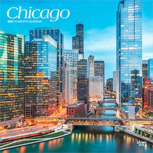 May include: A 2027 16-month calendar featuring a high-angle view of the Chicago skyline at dusk. The image displays illuminated skyscrapers, the Chicago River, and multiple bridges. The text reads Chicago 2027 16-month calendar and brown trout.