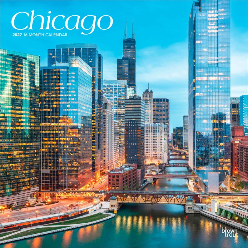 May include: A 2027 16-month calendar featuring a high-angle view of the Chicago skyline at dusk. The image displays illuminated skyscrapers, the Chicago River, and multiple bridges. The text reads Chicago 2027 16-month calendar and brown trout.