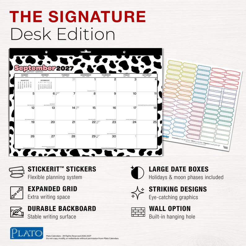 K&ouml;nnte beinhalten: Ein Schreibtischkalender f&uuml;r 2027 mit dem Titel THE SIGNATURE Desk Edition und einem schwarz-wei&szlig;en Kuhfleckenmuster am Rand. Der Kalender zeigt den September 2027 in einem Rasterlayout, erg&auml;nzt durch einen Bogen bunter Aufkleber zur Planung.