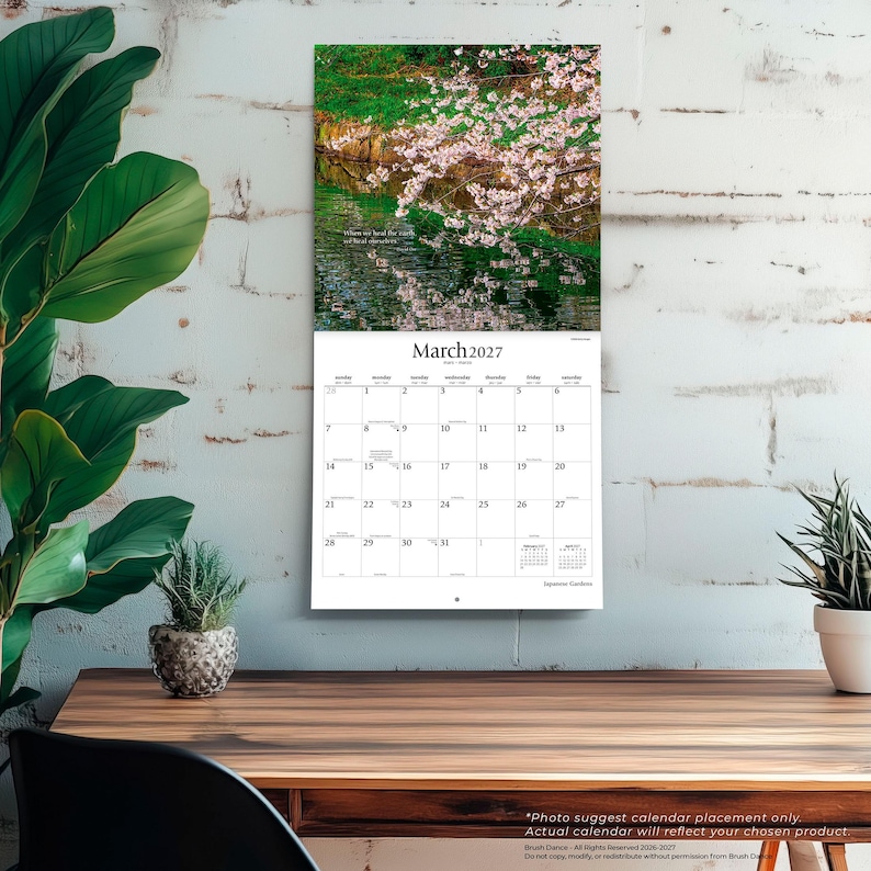 May include: A wall calendar for March 2027 featuring a photograph of cherry blossoms over a pond. The calendar grid displays the month, year, and days of the week. The text "March 2027" is printed at the top of the grid, with "Japanese Gardens" below.