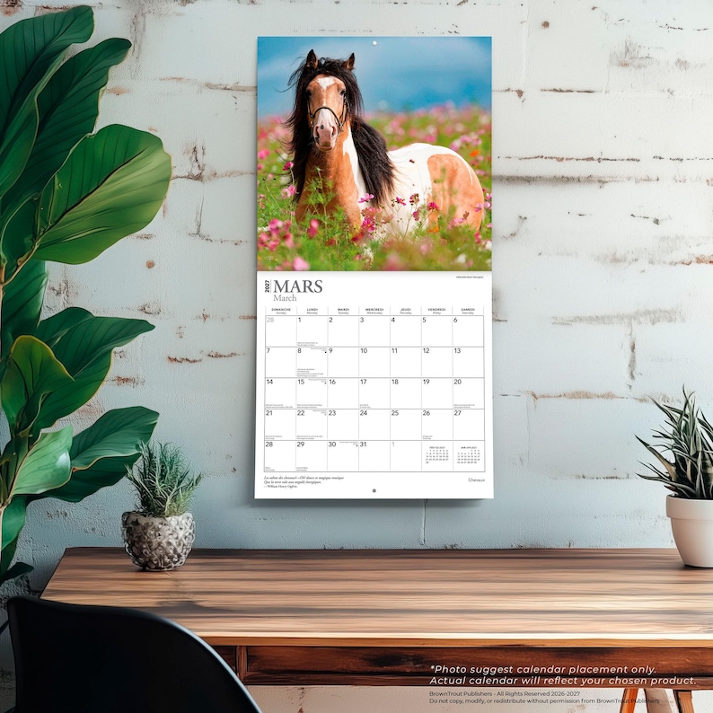 May include: A wall calendar for March 2027 featuring a photograph of a brown and white pinto horse standing in a field of pink wildflowers. The calendar grid displays the days of the month with the text MARS and March printed at the top.
