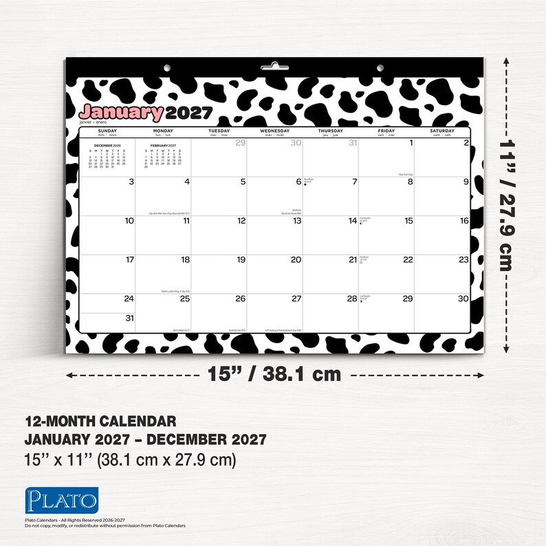 K&ouml;nnte beinhalten: Ein 12-Monats-Wandkalender f&uuml;r Januar 2027 bis Dezember 2027 mit einem schwarz-wei&szlig;en Kuhflecken-Rand. Der Kalender misst 38,1 cm mal 27,9 cm und zeigt ein Raster f&uuml;r Januar 2027, wobei der Monatsname in Rosa gedruckt ist.