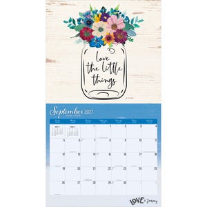 May include: A wall calendar for September 2027 featuring a mason jar illustration filled with colourful flowers and the text love the little things. The calendar grid displays days of the week and dates on a blue background with the text Love the Journey.