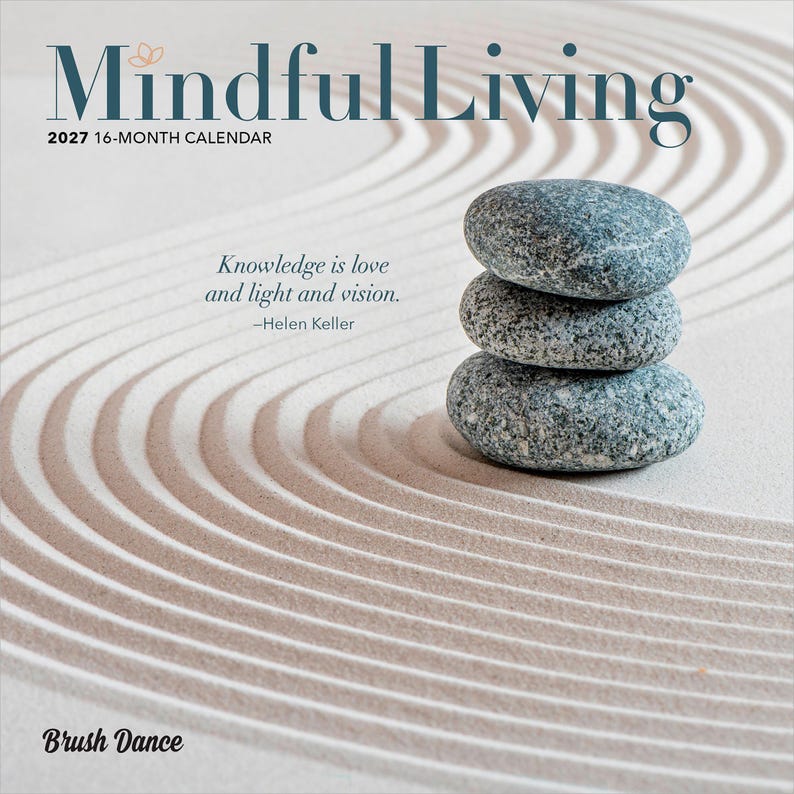 May include: A 2027 16-month calendar titled Mindful Living featuring a stack of three grey speckled stones on a raked sand background. The text reads Knowledge is love and light and vision by Helen Keller and the brand name Brush Dance.