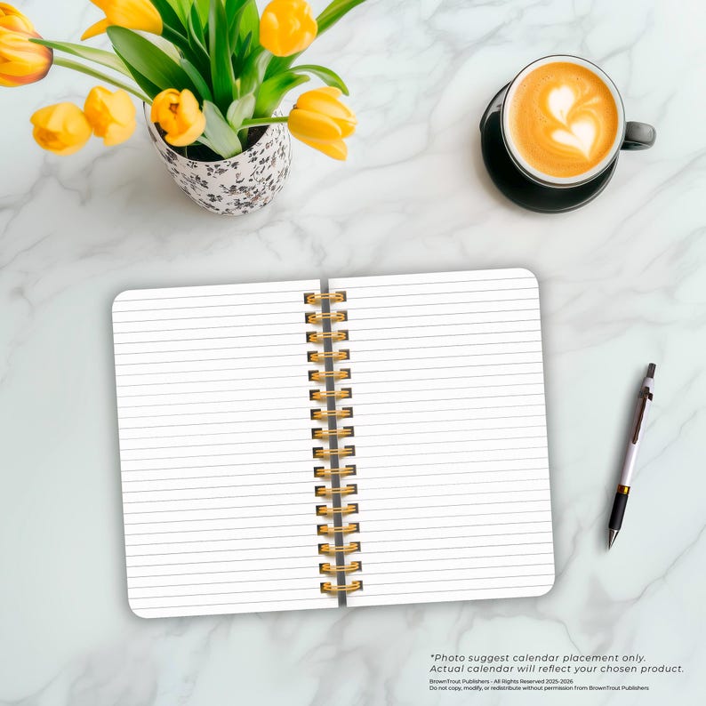 May include: A white spiral bound notebook with lined pages, a gold spiral binding, and a white background. The notebook is open to a blank page. A cup of coffee and a pen are also visible in the image.