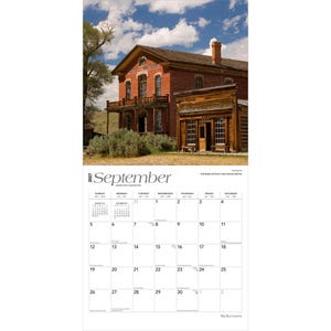 K&ouml;nnte beinhalten: Ein Wandkalender f&uuml;r September 2027 mit einem Foto eines historischen roten Backsteingeb&auml;udes namens Hotel Meade neben einem rustikalen Holzgeb&auml;ude unter einem blauen Himmel mit Wolken. Das Kalenderraster zeigt die Daten vom 1. bis zum 30.