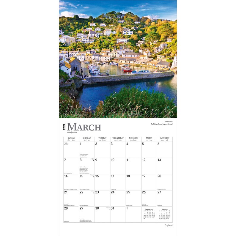 May include: A 2027 wall calendar for the month of March featuring a photograph of the Polperro fishing village in Cornwall, England. The image shows white buildings nestled on a green hillside overlooking a harbor with boats and blue water.