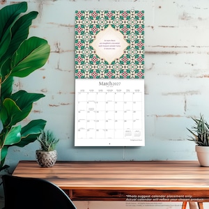 Op de afbeelding: Een wandkalender voor maart 2027 met een decoratief geometrisch patroon in groen-, rood- en cr&egrave;metinten. Het midden toont een ruitvormig tekstvak met het citaat: In tears there is laughter concealed; seek treasure amidst ruins, O sincere one.