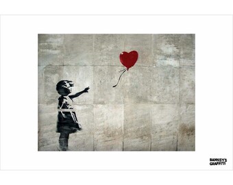May include: A print of Banksy's artwork depicting a girl reaching for a red heart-shaped balloon. The image is a stencil on a textured grey wall. The words "BANKSY'S GRAFFITI" are in the lower right corner.