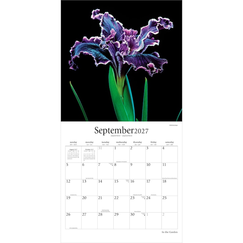May include: A wall calendar for September 2027 featuring a large, ruffled purple and blue iris flower against a solid black background. The calendar grid displays the days of the month with clear black text on a white background, including small monthly views.