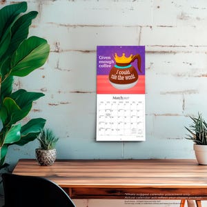 May include: A wall calendar for March 2027 featuring a graphic of a coffee pot wearing a gold crown. The text reads Given enough coffee I could rule the world. The background is purple with polka dots above a red horizontal stripe.