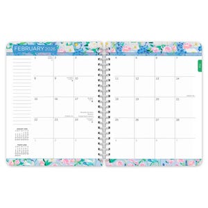 May include: A spiral-bound planner open to February 2026. The calendar pages are white with a floral border of blue, pink, and white flowers. The month's name is in blue. The calendar includes dates, days, and space for notes.