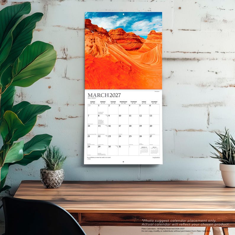 Op de afbeelding: Een wandkalender voor maart 2027 met een levendige foto van oranje zandsteenformaties onder een blauwe lucht. Het kalenderraster toont de dagen van de maand met zwarte tekst op een witte achtergrond, inclusief kleine tekst onderaan.