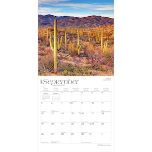 May include: A 2027 wall calendar for the month of September featuring a landscape photograph of Saguaro National Park. The image displays tall green saguaro cacti in a desert landscape with mountains under a blue sky. The calendar grid is white.