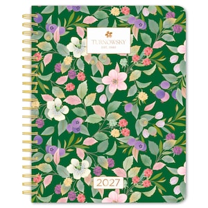 May include: A spiral-bound planner with a dark green cover featuring a botanical pattern of pink flowers, purple berries, and green leaves. A white rectangular label displays the text TURNOWSKY EST. 1940 and a second label shows the year 2027.