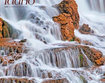 Puede incluir: Un calendario de 16 meses para 2027 titulado wild & scenic Idaho que presenta una fotografía de una cascada de varios niveles que cae sobre formaciones rocosas de color naranja-marrón con parches de musgo verde. El texto brown trout está impreso.